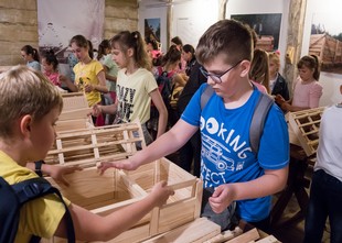 Dzieci składają dom z drewnianych elementów
